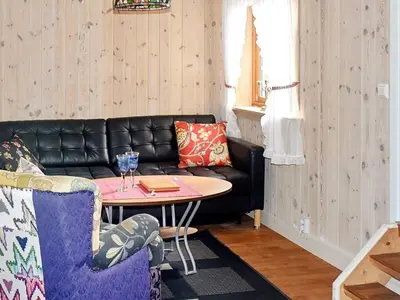 a living room with a black leather couch and a table at 8 person holiday home in FREI in Frei