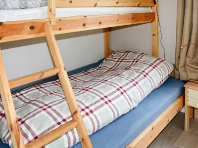 a bunk bed in a room with a ladder at 8 person holiday home in FREI in Frei