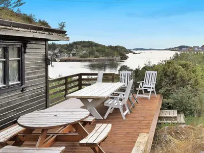 a wooden deck with a picnic table and chairs at 8 person holiday home in FREI in Frei