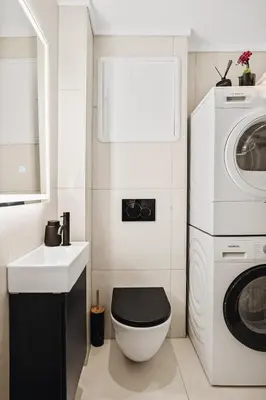 a bathroom with a toilet and a sink and a washing machine at Modern & Chic Apartment Luxurious Details in Bergen