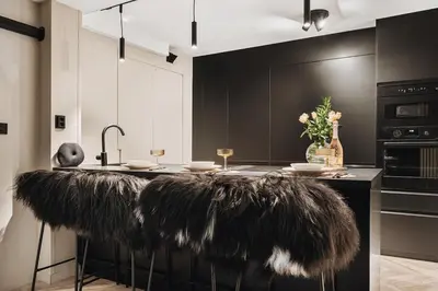 a kitchen with a black island with feathers on it at Modern & Chic Apartment Luxurious Details in Bergen
