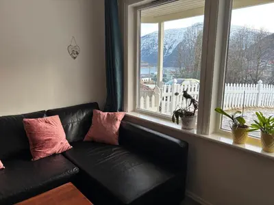 a black leather couch sitting in front of a window at Solsiden apartment in Sogndal