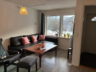a living room with a black couch and a table at Solsiden apartment in Sogndal