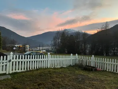 a white picket fence with a view of mountains at Solsiden apartment in Sogndal