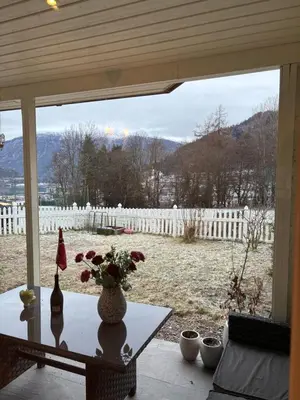 a table with a vase of flowers on top of it at Solsiden apartment in Sogndal