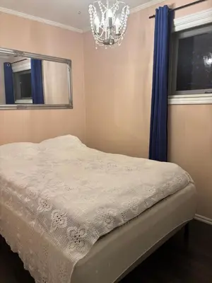 a bedroom with a bed and a chandelier at Solsiden apartment in Sogndal