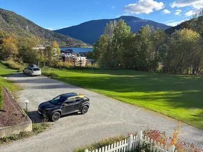 a car parked on a road next to a green field at Solsiden apartment in Sogndal