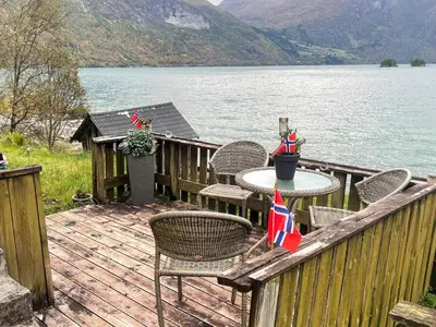a wooden deck with chairs and a table with a flag at 3 person holiday home in STRYN-By Traum in Stryn