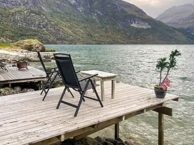 a black chair sitting on a dock next to the water at 3 person holiday home in STRYN-By Traum in Stryn