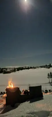 a fire pit in the snow with the moon in the sky at Family Cabin With Firepit At Søndre Fjellstølen in Reinli