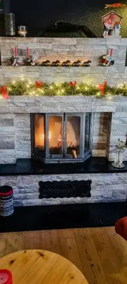 a fireplace in a room with a brick wall at Family Cabin With Firepit At Søndre Fjellstølen in Reinli