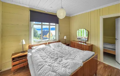a bedroom with a large bed and a window at 6 Bedroom Lovely Home In Holmedal in Holmedal