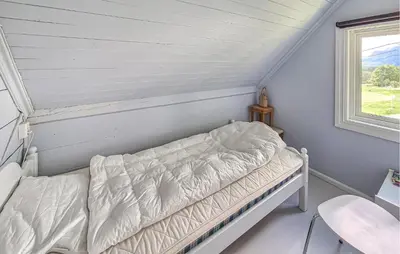 a bed in a room with a window at 6 Bedroom Lovely Home In Holmedal in Holmedal