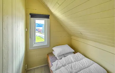 a small room with a bed and a window at 6 Bedroom Lovely Home In Holmedal in Holmedal