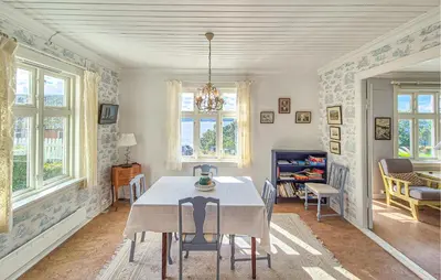 a dining room with a table and chairs and windows at 6 Bedroom Lovely Home In Holmedal in Holmedal