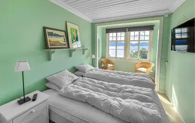 a bedroom with a bed and a window at 6 Bedroom Lovely Home In Holmedal in Holmedal