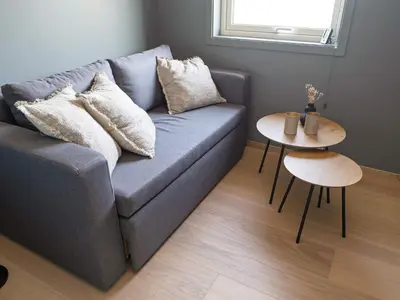 a living room with a blue couch and two tables at 10 person holiday home in INDERØY-By Traum in Kjerkenesvåg