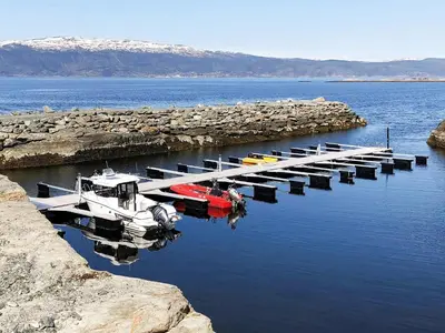 a group of boats docked at a dock in the water at 10 person holiday home in INDERØY-By Traum in Kjerkenesvåg