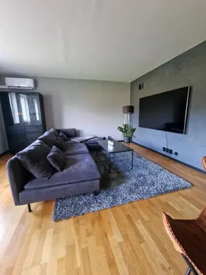a living room with a couch and a flat screen tv at Cozy apartment close to Trondheim City in Melhus