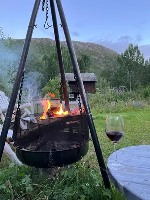 a fire pit with a glass of wine next to a table at Ski lodge 7 min from Hemsedal Ski Center by Car in Fausko
