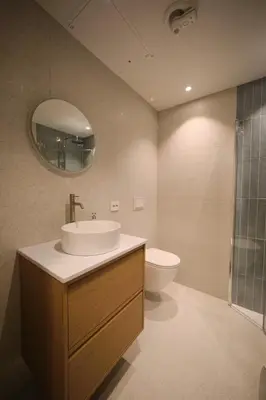 a bathroom with a sink and a toilet and a mirror at Cozy and practical studio in the city center in Ålesund