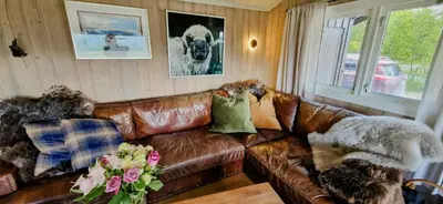 a living room with a brown leather couch at Mountain Cabin With Panoramic Views In Brakastølen in Ron