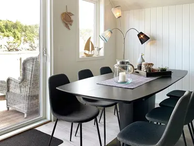 a dining room with a table and chairs and a window at 8 person holiday home in Urangsvåg in Ervik