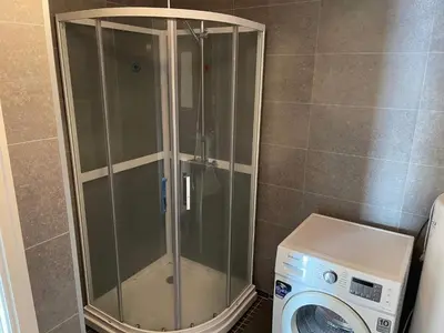 a shower in a bathroom next to a washing machine at 6 person holiday home in Rubbestadneset in Rubbestadneset