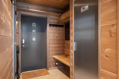 a walk in closet with a gray door and wooden walls at Panoramahytte med fjellutsikt in Sogndal