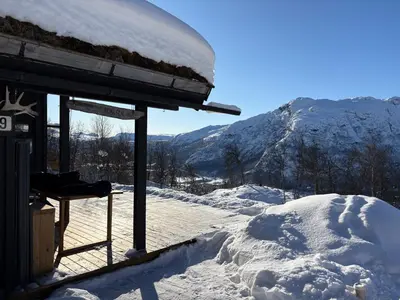 a snow covered roof of a building with a snow covered mountain at Cosy cabin in Hemsedal with ski in-ski out to Solheisen in Hemsedal
