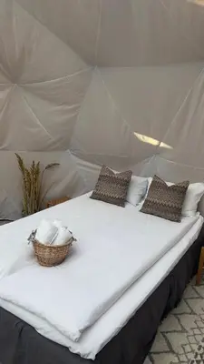 a bed in a tent with a basket on it at Vollsnes Glamping in Stryn