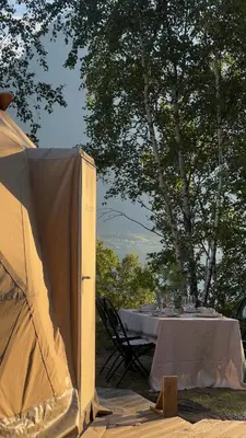 a tent with a table and chairs in a field at Vollsnes Glamping in Stryn