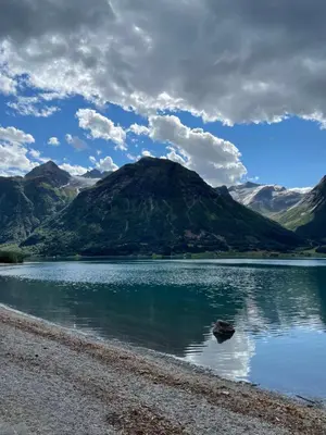 a mountain reflection in a lake with a cloudy sky at Vollsnes Glamping in Stryn