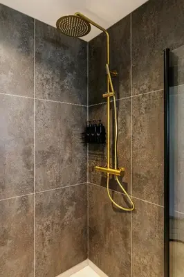 a shower with a yellow shower head in a bathroom at Fjord Vista - Top floor apartment in Ålesund in Ålesund