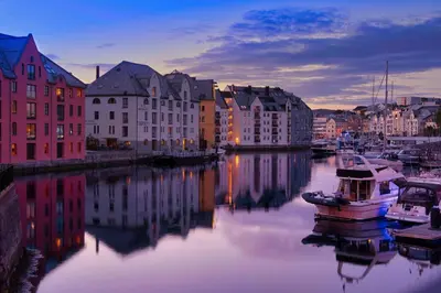 a city with buildings and a boat in the water at Fjord Vista - Top floor apartment in Ålesund in Ålesund