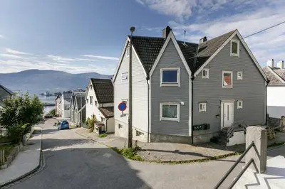 a house on a street in front of the ocean at Fjord Vista - Top floor apartment in Ålesund in Ålesund