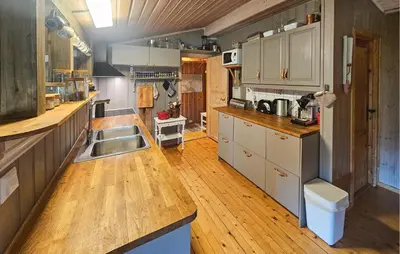 a kitchen with a sink and wooden floors and cabinets at 3 Bedroom Lovely Home In Dagali in Dagali