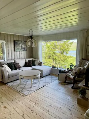 a living room with a couch and a table at Idyllic cottage with a view, close to Gardermoen Airport in Hurdal
