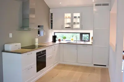 a kitchen with white cabinets and a window at Moderne hus - sentralt, rolig med gratis parkering in Bergen