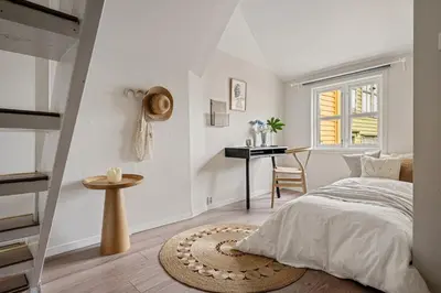 a white bedroom with a bed and a desk at Charming apt in the centre of Bergen in Bergen