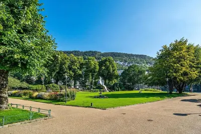 a park with a fountain and grass and trees at Historic retreat in the middle of town in Bergen