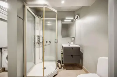 a bathroom with a shower and a toilet and a sink at Historic retreat in the middle of town in Bergen