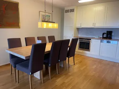 a kitchen with a wooden dining table and chairs at Sentral Og Moderne Leilighet Med Heis Og Garasje in Beitostøl