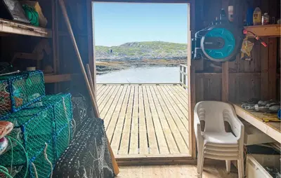 an open door to a deck with a chair at Nice Home In Sauøya With House Sea View