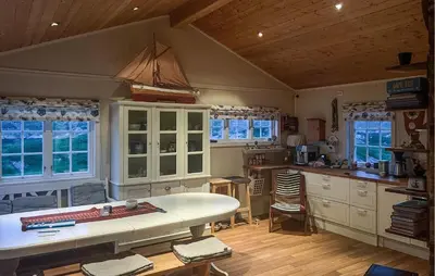 a kitchen with a large white table and some windows at Nice Home In Sauøya With House Sea View