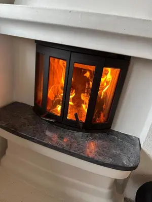 a fire burns in a brick fireplace at Peaceful cabin with secluded location in Ål