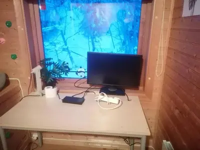 a computer monitor sitting on a table in front of a window at The top half of a house with sea view in Steinkjer