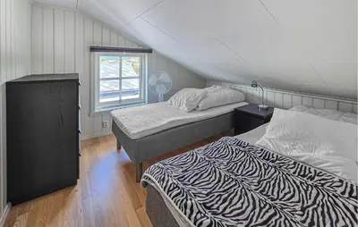 a bedroom with two beds and a window at Beautiful Home In Fitjar With House Sea View in Fitjar