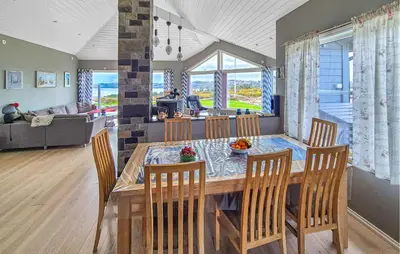 a dining room and living room with a table and chairs at Beautiful Home In Fitjar With House Sea View in Fitjar