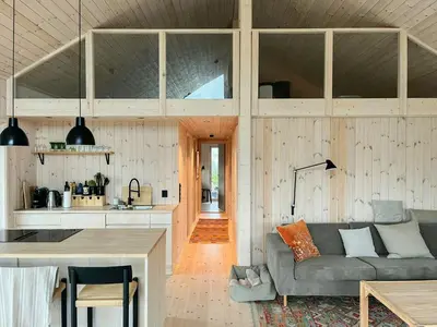 a living room with a couch and a kitchen at Architect-Designed Cabin With Views Of Sigdal in Eggedal
